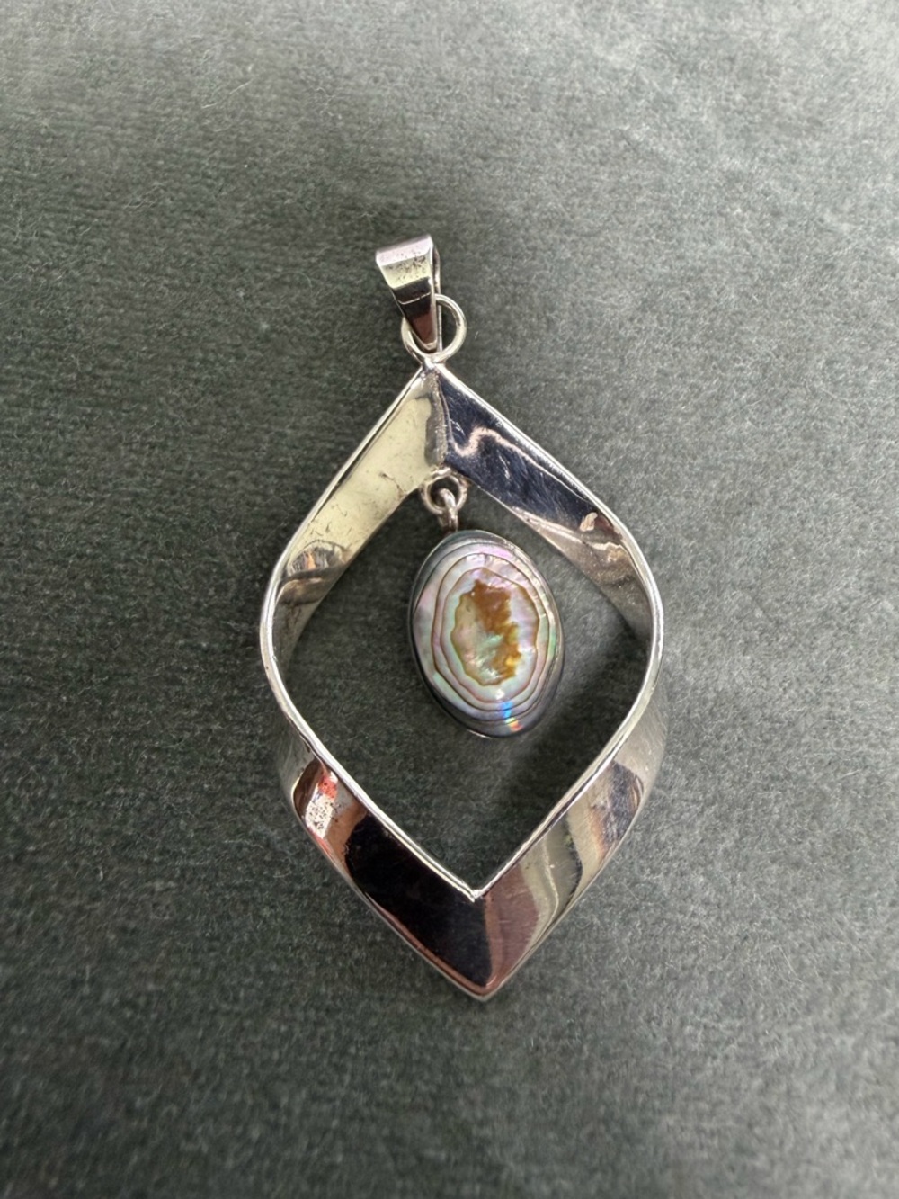 sterling silver pendant featuring a dangling iridescent abalone stone